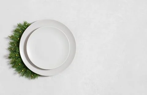 Christmas minimal table setting with empty plate and fir branches on gray bac Stock Photos