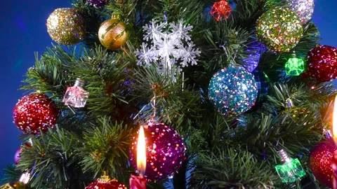 Christmas in motion behind three burning candles close-up green tree Stock Footage 166703056