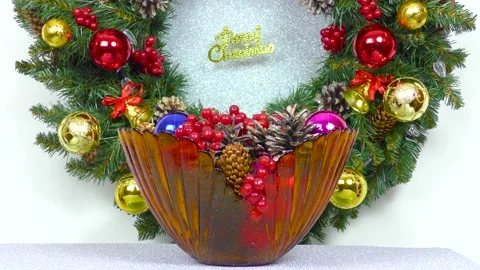 Christmas in motion close-up vase in front of decorated Christmas wreath Video stock 166345442
