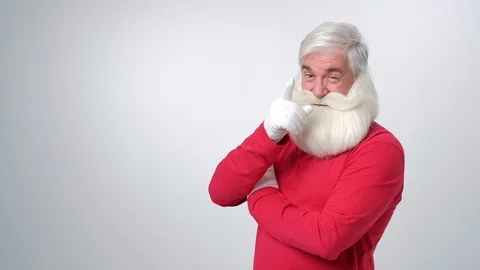 Christmas old man with beard in red hat, winking and point finger on camera Stock Footage 123421264