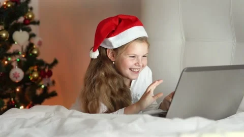 Christmas online family congratulations. girl in in Santa hat using notebook Stock Footage