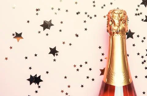 Christmas or New Year pink background with bottle of sparkling wine, rose cha Foto stock