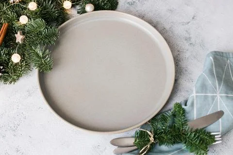 Christmas or New Year table setting with ceramic plate, fir branch with decor Stock Photos