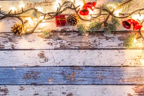 Christmas ornaments and pine branches on wooden table with yellow lights Stock Photos