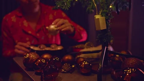 Christmas Ornaments Spread Across a Table as a Woman Prepares Decorations for a Stock Footage 338195723