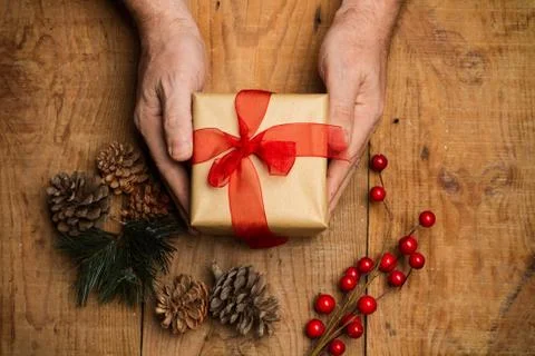 Christmas packages on a man hands on a rustic wooden table Stock Photos