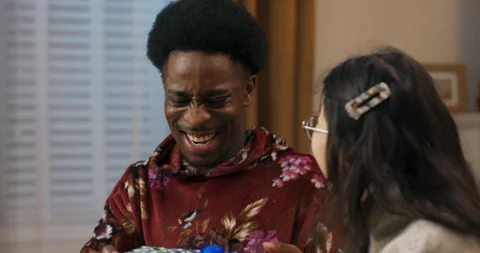 Christmas party. An African-looking guy gets present. The Asian-looking girl Stock Footage 201758006