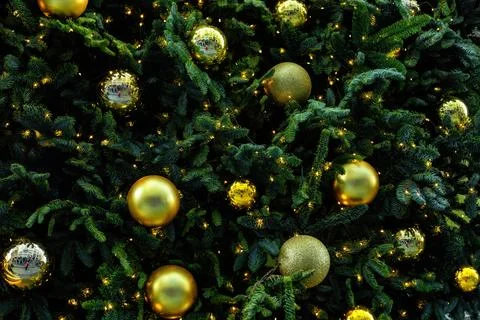 Christmas pattern with green branch pine needle illuminated, golden baubles Foto stock