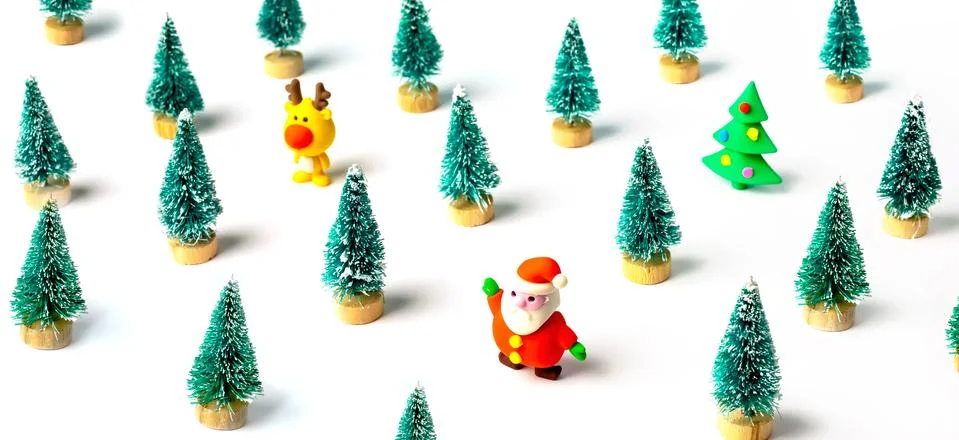 Christmas pattern made with pine trees and small rubber Santa Claus and deer. Stock Photos