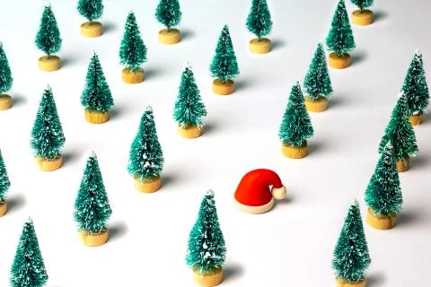 Christmas pattern made with pine trees and small rubber Santa Claus hat. Stock Photos