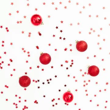 Christmas pattern made of red balls decoration with confetti on white backgro Stock Photos