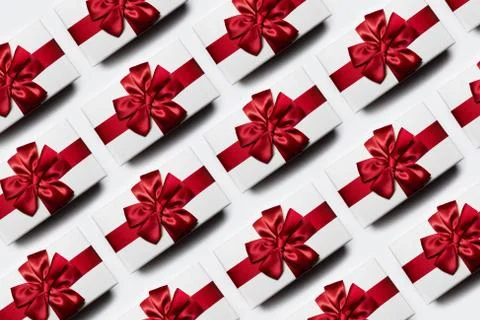 Christmas pattern of white gift boxes with red bow, isolated white background. Stock Photos