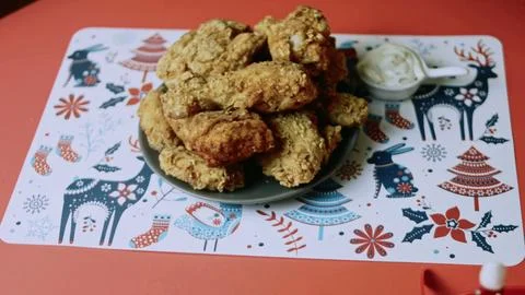 Christmas-patterned table presenting a finished chicken meal Stock Photos