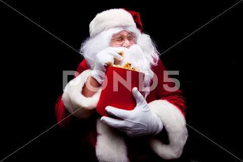Christmas. Photo of Santa Claus gloved hand With a red bucket with popcorn, on a Stock Photos