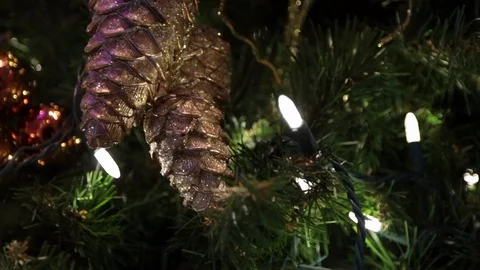 Christmas pine cone decorations on tree with lights close Stock Footage 91198357