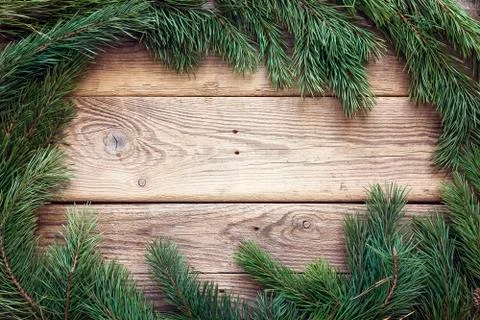 Christmas pine tree branches on old wooden board. Space for text. Stock Photos