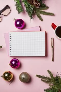 Christmas pink background with blank notebook, pen, christmas decorations and Stock Photos
