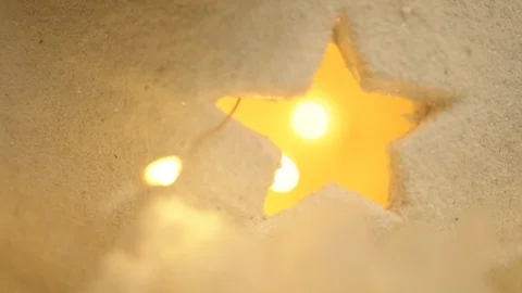 Christmas plaster decor with star-shaped hole and yellow garland lights inside Stockbeeldmateriaal 100761308