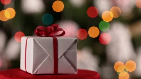 Christmas present spinning in front of blinking lights Video stock 81389509