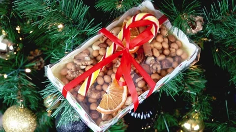 Christmas present on spruce branches, LED light. Nuts, caramel candy cane Stock Footage 211330614