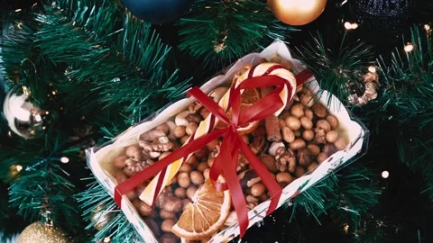 Christmas present on spruce branches, LED light. Nuts, caramel candy cane 스톡 동영상 220000045