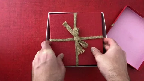 Christmas present unboxing on a red surface Stock Footage 144744170