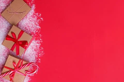 Christmas presents in boxes on red table with snow. Stock Photos