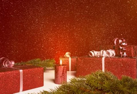 Christmas presents on a table in front of red background with snow Stock Photos