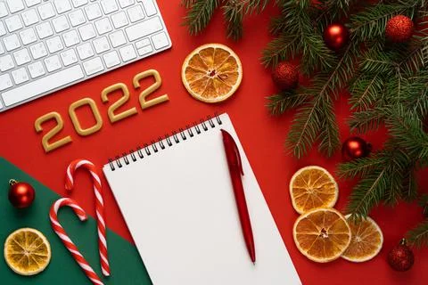 Christmas red background with spruce branches and balls, pen and notebook with a Foto stock