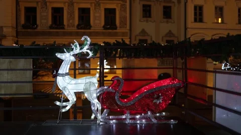 Christmas reindeer and red sleigh glowing on festive city balcony Stock Footage 325073722