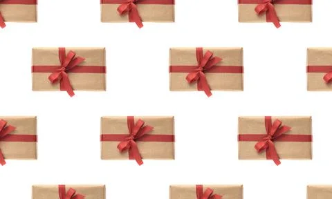 Christmas seamless pattern . Giftbox wrapped in craft paper with red ribbon i Stock Photos