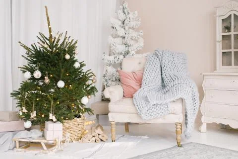 Christmas Sleigh with gifts and a blanket, a chair with pillows near the Chri Stock Photos