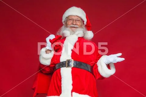 Christmas. Smiling Santa Claus held out his empty hand with his palm up, and in Stock Photos