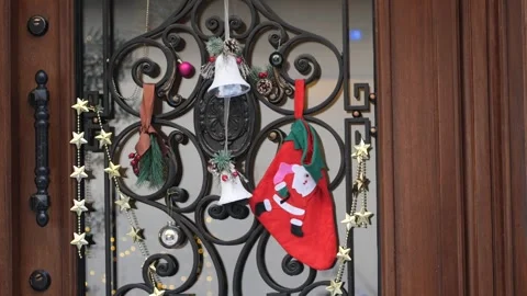 Christmas stocking and silver bells hanging on wrought iron door with festi.. Stock Footage 332056894