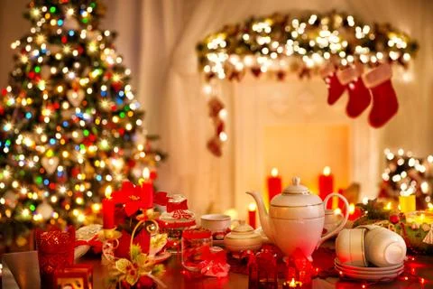Christmas Table Dinner served in front of decorated Xmas Tree. Fireplace Stock Photos