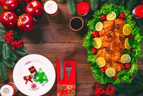 Christmas table dinner time with roasted meats decorated in Christmas style.  Stock Photos