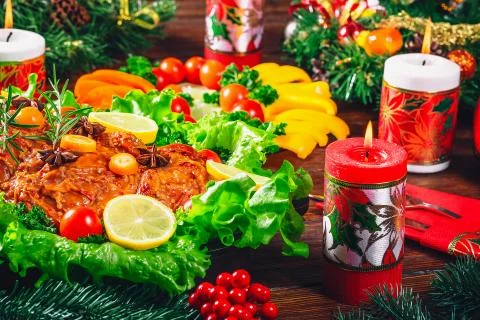 Christmas table dinner time with roasted meats decorated in Christmas style.  Stock Photos