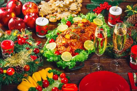 Christmas table dinner time with roasted meats decorated in Christmas style w Stock Photos