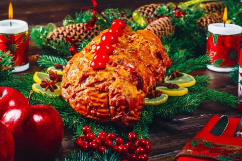 Christmas table dinner time with roasted meats, candles and New Year dcor. Ba Stock Photos