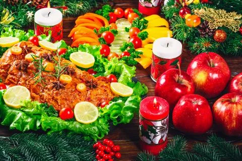 Christmas table dinner time with roasted meats decorated in Christmas style.  Stock Photos
