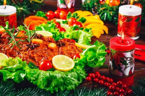 Christmas table dinner time with roasted meats, candles and New Year dcor. Ba Stock Photos