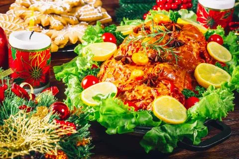 Christmas table dinner time with roasted meats, candles and New Year dcor. Ba Stock Photos