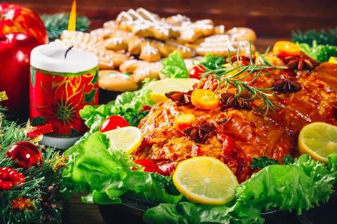 Christmas table dinner time with roasted meats, candles and New Year dcor. Ba Stock Photos
