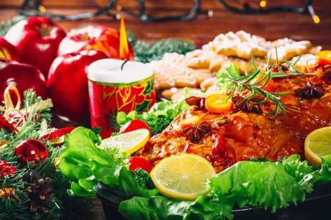 Christmas table dinner time with roasted meats, candles and New Year dcor. Ba Stock Photos
