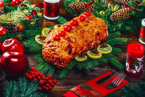 Christmas table dinner time with roasted meats, candles and New Year dcor. Ba Stock Photos