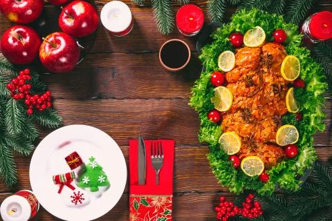 Christmas table dinner time with roasted meats decorated in Christmas style.  Stock Photos
