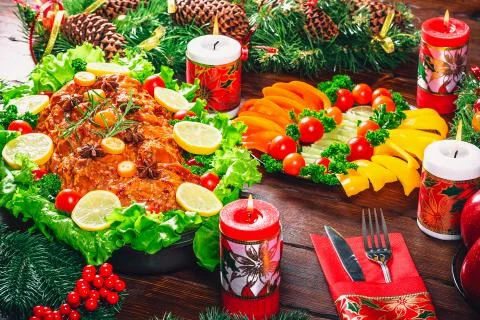 Christmas table dinner time with roasted meats decorated in Christmas style.  Stock Photos
