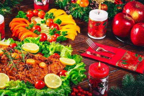 Christmas table dinner time with roasted meats decorated in Christmas style.  Stock Photos