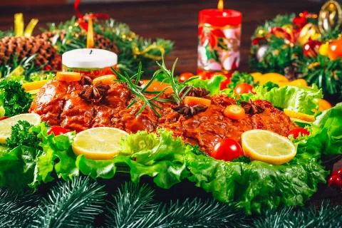 Christmas table dinner time with roasted meats, candles and New Year dcor. Ba Stock Photos
