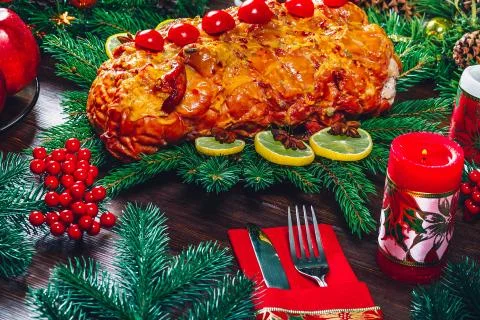 Christmas table dinner time with roasted meats, candles and New Year decor. B Stock Photos